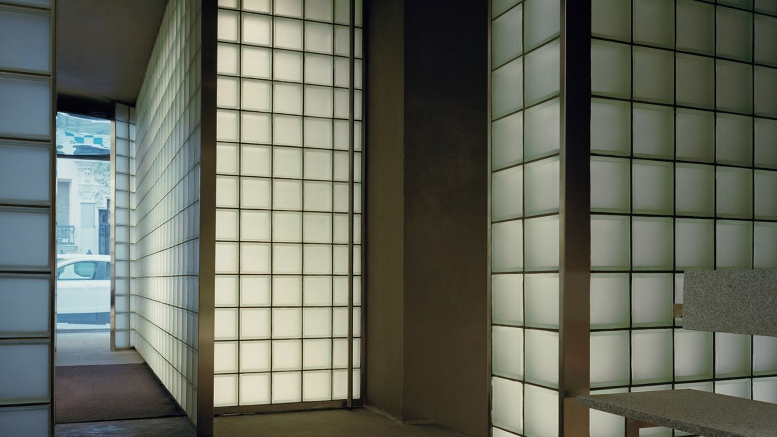 Riela Madrid entrance of translucent glass-block walls and a granite counter opening onto the street