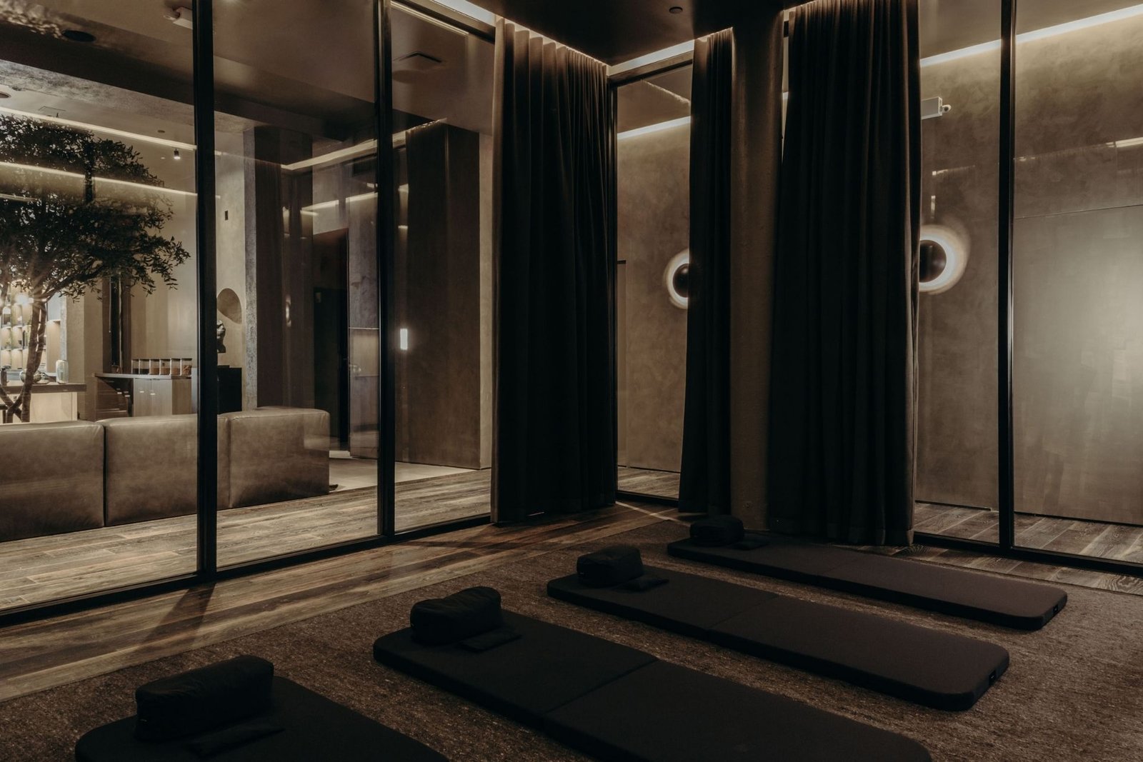 Remedy Place meditation and breathwork studio with floor mats, glass partitions and textured plaster walls