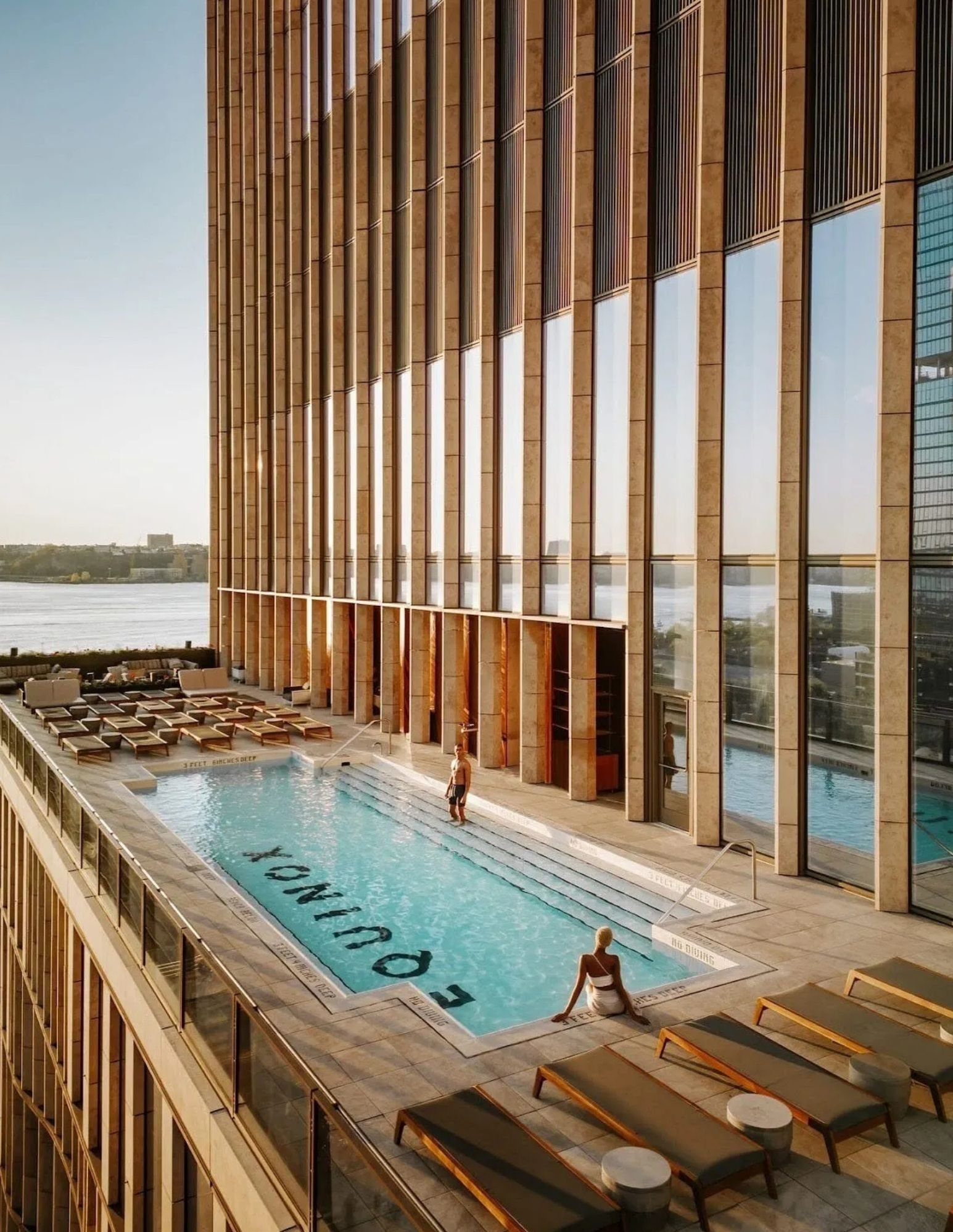 Pool deck of the Equinox Hotel Hudson Yards with the tower and Hudson River
