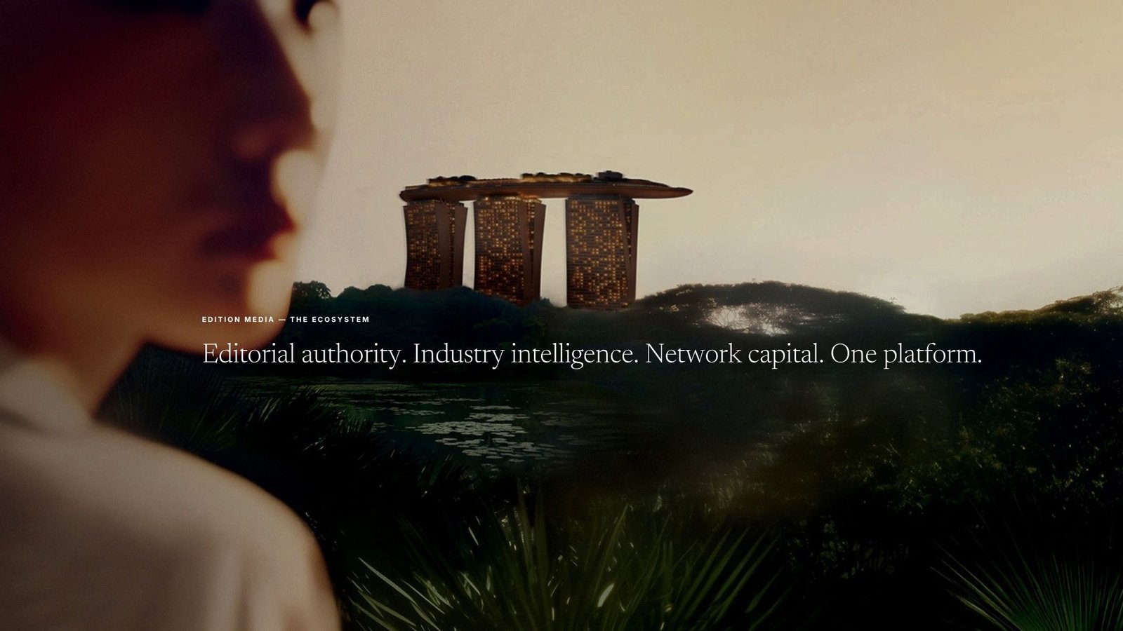 Edition Media 'The Ecosystem' banner: a blurred woman in profile gazes across a misty tropical jungle at dusk toward the illuminated Marina Bay Sands, its towers glowing gold above the treeline, overlaid with 'Editorial authority. Industry intelligence. Network capital. One platform.'