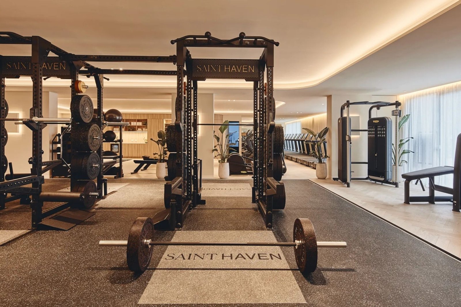 Saint Haven strength-training floor with black power racks and a branded lifting platform